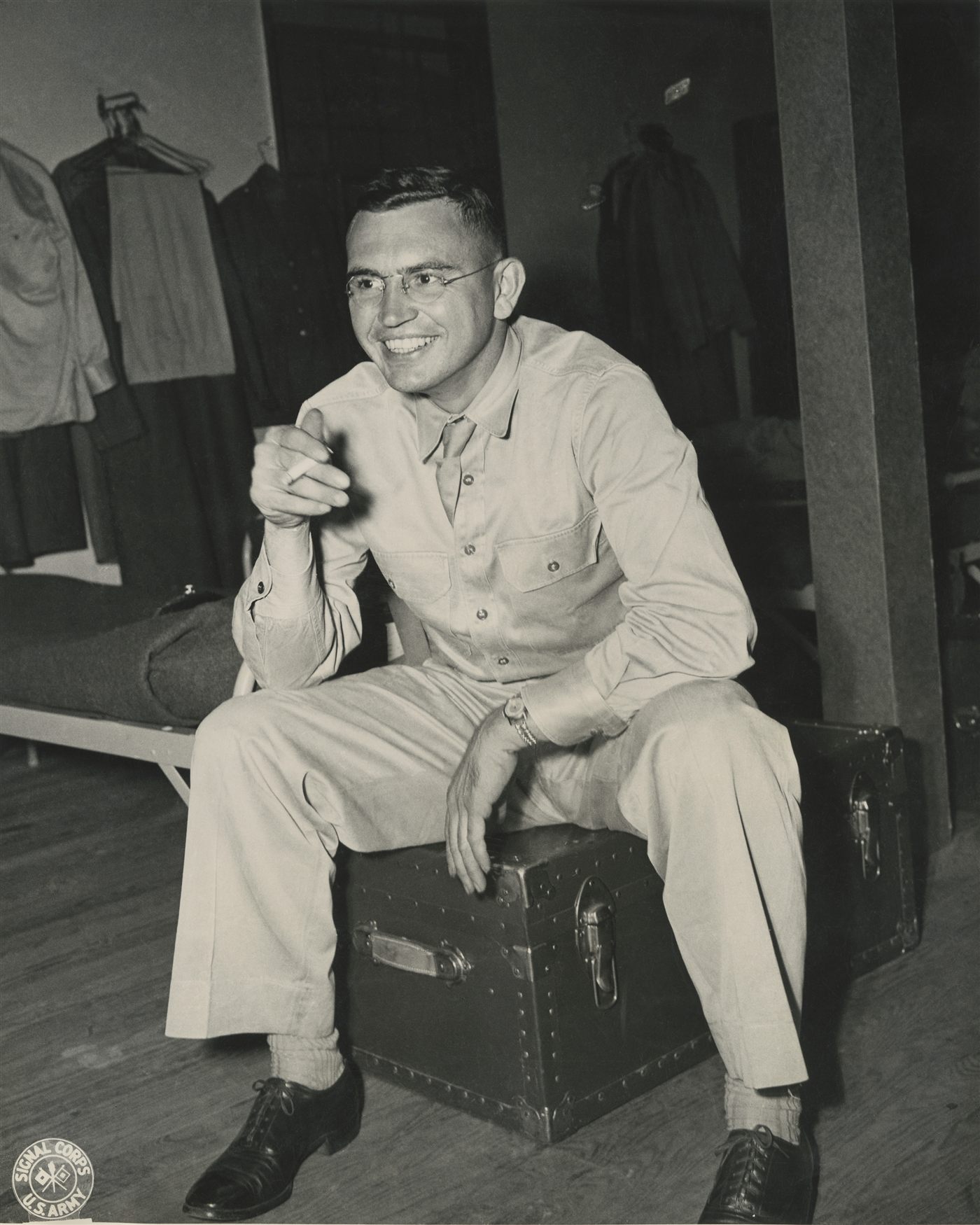 Miller's founder Bill Miller in U.S. Army Signal Corps uniform, seated on a footlocker, smiling